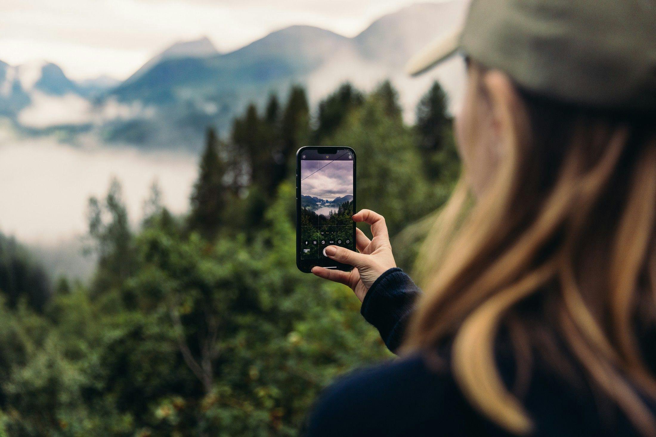 Girl taking picture of natural landscape