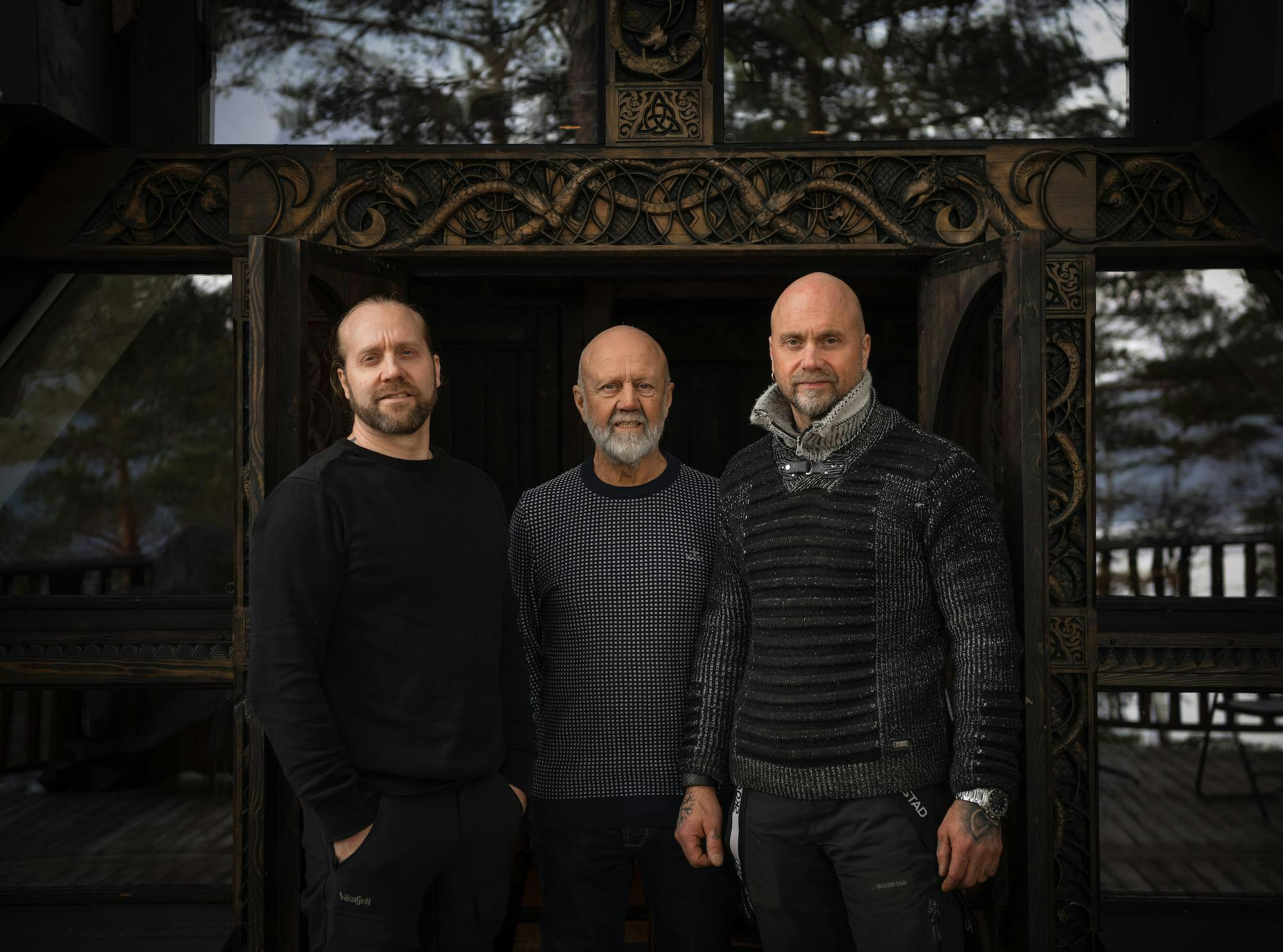 Men in front of wood carved house